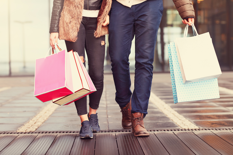 couple walking down the street carrying shopping bags